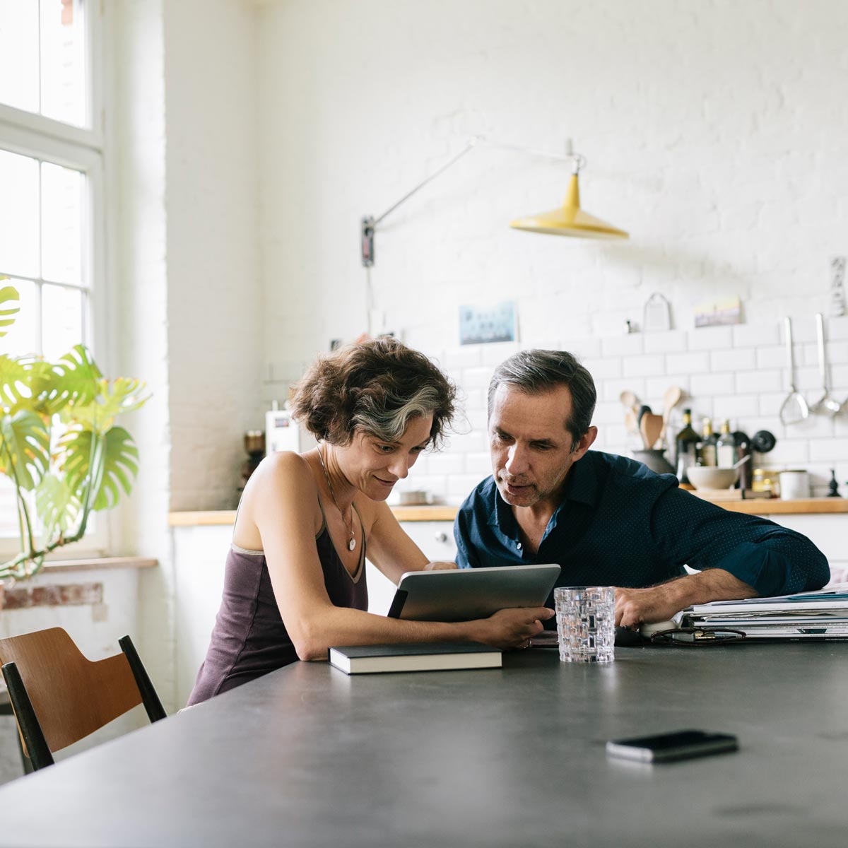 Middle-aged couple looking at information on their tablet Middle-aged couple looking at information on their tablet