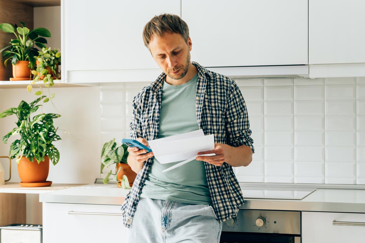 Person reading through their mail while in their household Person reading through their mail while in their household